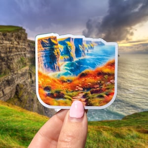 May include: A colorful sticker featuring a scenic view of the Cliffs of Moher in Ireland. The sticker shows a rocky coastline with a path leading to the edge of the cliffs. The ocean is a vibrant blue, and the sky is a mix of blue and gray with clouds.