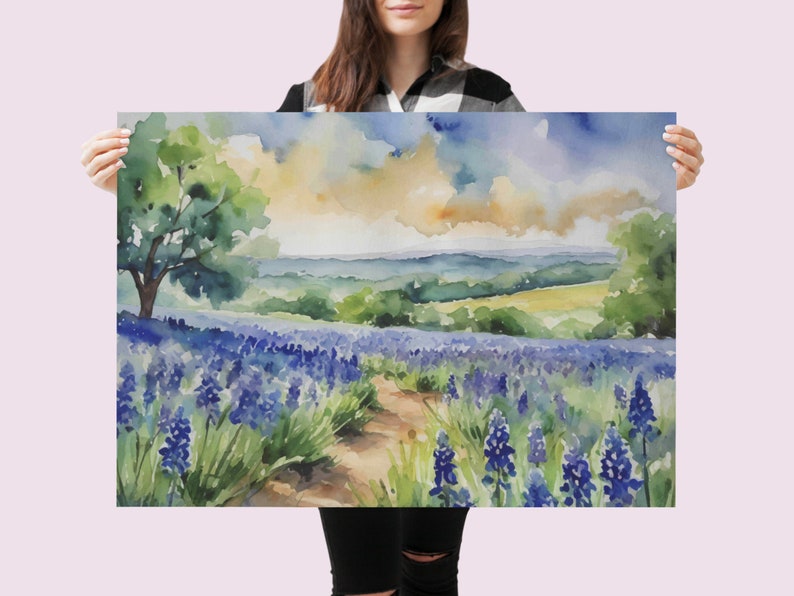 May include: Watercolour painting of a field of blue wildflowers with a dirt path leading through the centre. A green tree is in the background with a view of rolling hills and a cloudy sky.