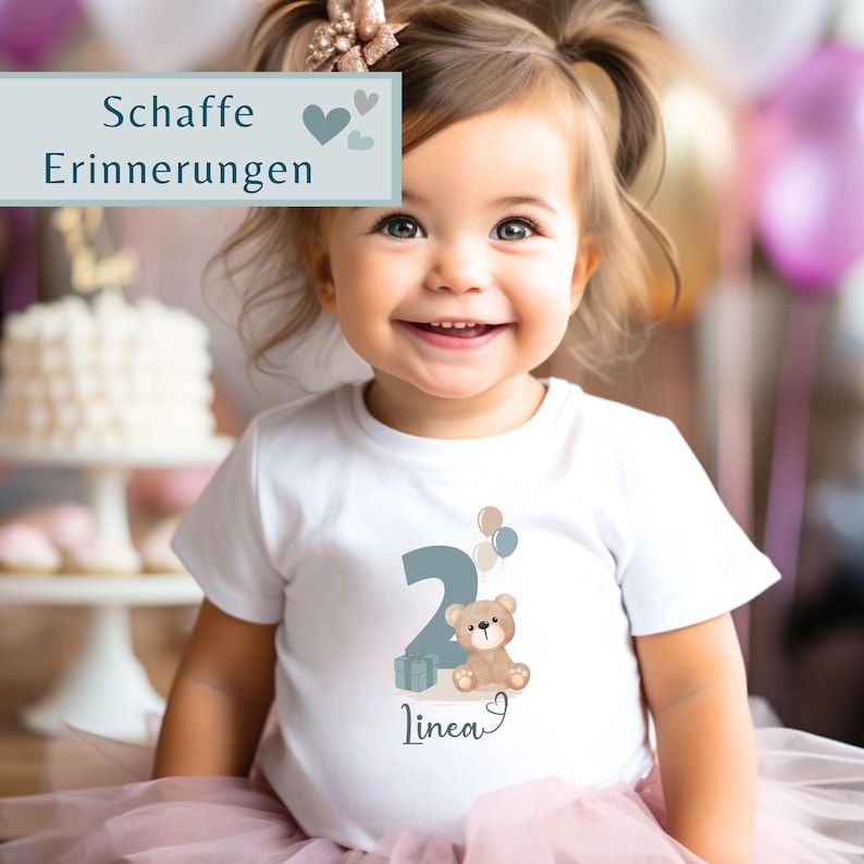 Peut inclure: Un t-shirt blanc &agrave; manches courtes orn&eacute; d'un motif repr&eacute;sentant le chiffre deux, un ours en peluche marron, un cadeau et trois petits ballons. Le pr&eacute;nom Linea est inscrit sous le motif. Un encadr&eacute; affiche les mots Schaffe Erinnerungen.