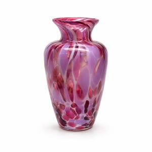 May include: A decorative glass vase with a flared top and a rounded body. The vase features a pattern of pink, purple, and white swirls and speckles. The vase is approximately 10 inches tall.