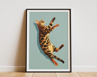 May include: A framed art print depicting a Bengal cat in a dynamic pose. The cat's coat displays a pattern of black spots and stripes on a tan base. The artwork is set against a pale blue background, creating a visually appealing contrast.
