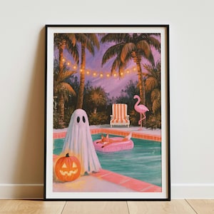 Op de afbeelding: Een ingelijste kunstdruk van een zwembad bij schemering met een witte geest naast een oranje pompoen. Een vos drijft op een roze band in het water, terwijl een roze flamingobeeld en een gestreepte stoel aan de rand van het zwembad staan.