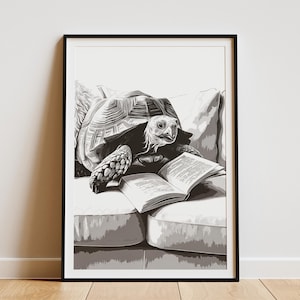 May include: Black and white framed art print of a tortoise reading a book while resting on a sofa. The tortoise is the focal point, with detailed shading and texture. The open book displays text.
