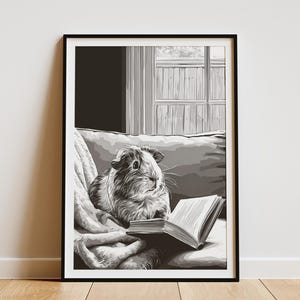 May include: Monochrome framed print featuring a guinea pig engrossed in a book. The guinea pig is seated on a cushion and blanket. A window with a view is in the background. The artwork is a grayscale illustration.