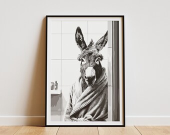 May include: Framed monochrome art print depicting a donkey in a bathroom, wrapped in a towel. The donkey is facing the viewer, with large ears and a towel draped over its shoulders. The background shows a tiled wall and toiletries.