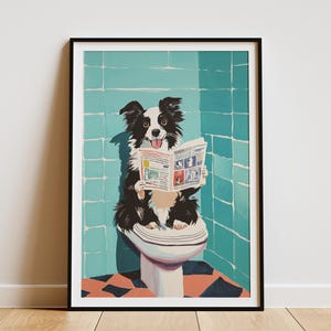 May include: Framed art print featuring a black and white Border Collie sitting on a toilet, reading a newspaper. The background shows a teal tiled wall and a black and orange checkered floor. The dog has its tongue out.