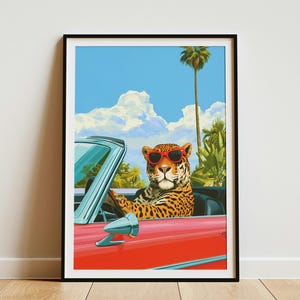 May include: A framed art print featuring a leopard wearing red sunglasses while driving a red convertible car. The background shows a bright blue sky with white clouds, a tall palm tree, and lush green tropical foliage under the sun.