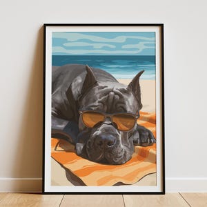 May include: Framed art print of a dog wearing sunglasses on a beach. The dog is dark grey, resting on an orange and white striped towel. The background shows a blue sky and ocean. The artwork is framed in black.