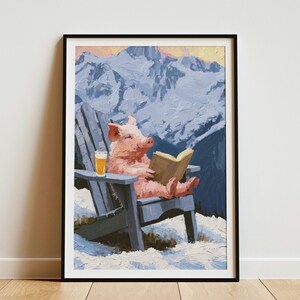 May include: A framed oil painting print featuring a pink pig sitting in a blue Adirondack chair in a snowy mountain landscape. The pig is holding an open book and a glass of beer is resting on the chair arm. The background shows jagged, snow-covered peaks under a soft sky.