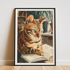 May include: A framed art print of a Bengal cat reading a book. The cat has a brown and black striped coat and green eyes. The artwork is set in a room with plants and natural light.