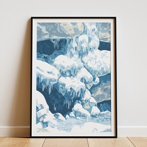 Op de afbeelding: Een ingelijste kunstdruk die een winterlandschap met een waterval afbeeldt. Het kunstwerk gebruikt blauw, wit en grijs, met gedetailleerde illustraties van ijsformaties en met sneeuw bedekte rotsen. De print wordt op een houten vloer gepresenteerd.
