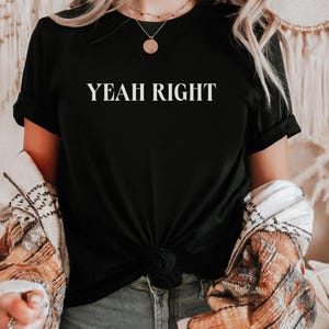 May include: Black t-shirt with the text "YEAH RIGHT" printed in white on the front.