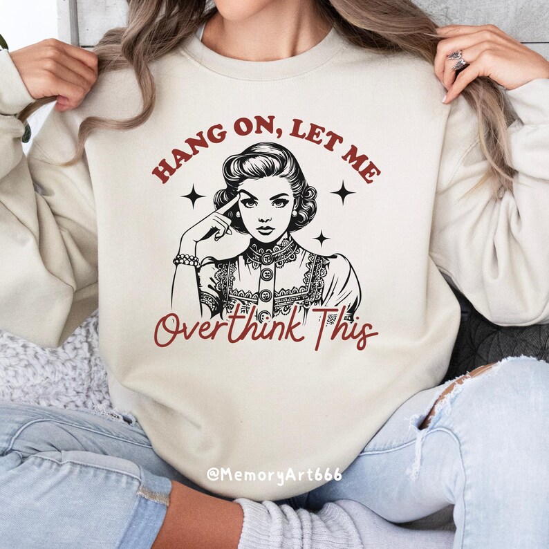A vintage retro-style illustration of a 1950s woman with curled hair, resting her finger on her temple in a thoughtful pose. The text reads “HANG ON, LET ME” above and “Overthink This” below in playful retro typography. Monochrome hand-drawn line art with mid-century cartoon style and sparkle accents on a warm neutral background. Anxiety and mental health humor quote design, perfect for funny women’s shirts, mugs, tote bags, stickers, and digital crafts. Digital download SVG and PNG files.