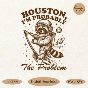 以下が含まれることがあります： 茶色と白のイラストで、ロケットに乗ったアライグマの宇宙飛行士が描かれています。「HOUSTON, I'M PROBABLY The Problem」というテキストが入っています。デザインには惑星と星が含まれており、MemoryArt666のロゴがあります。