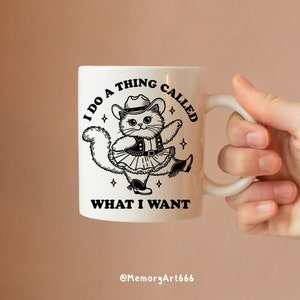 A funny retro-style illustration of a sassy cowboy cat dancing confidently, wearing a western hat, boots, and a skirt. The sarcastic quote reads “I Do A Thing Called What I Want.” Vintage hand-drawn line art with playful details and a bold, confident attitude. Adult humor design with a positive, self-love vibe, perfect for shirts, tote bags, mugs, stickers, and digital crafts. SVG and PNG digital download.