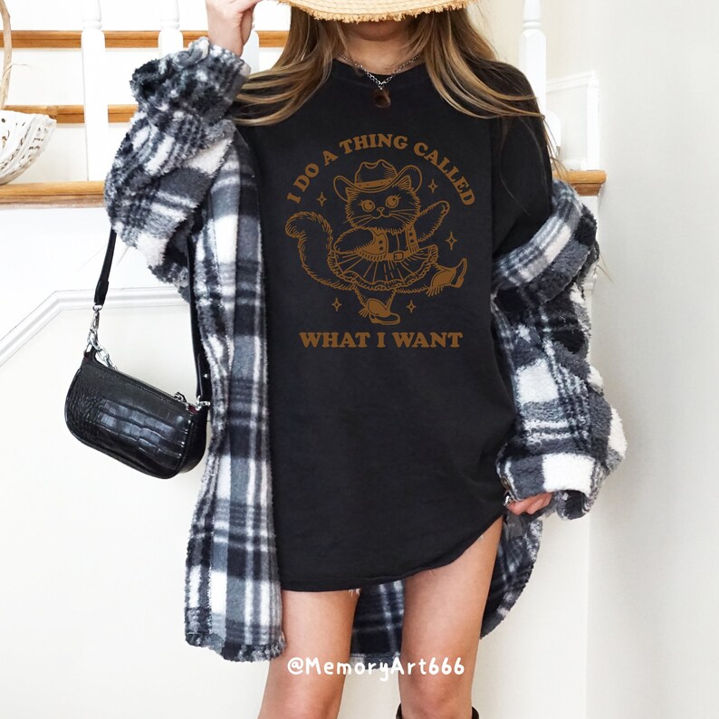 A funny retro-style illustration of a sassy cowboy cat dancing confidently, wearing a western hat, boots, and a skirt. The sarcastic quote reads “I Do A Thing Called What I Want.” Vintage hand-drawn line art with playful details and a bold, confident attitude. Adult humor design with a positive, self-love vibe, perfect for shirts, tote bags, mugs, stickers, and digital crafts. SVG and PNG digital download.