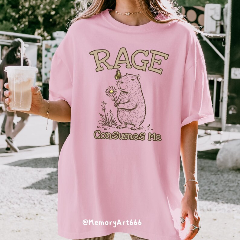 Funny capybara meme PNG SVG design featuring a cute vintage-style capybara holding a daisy flower with a butterfly resting on its head and bold retro “RAGE Consumes Me” typography. Funny sarcastic animal graphic with whimsical hand-drawn line art, soft neutral tones, and trendy unhinged aesthetic. Perfect for funny t-shirts, hoodies, mugs, tote bags, stickers, sublimation projects, Cricut SVG cut files, retro boutique apparel, instant digital download, 300 DPI transparent background.