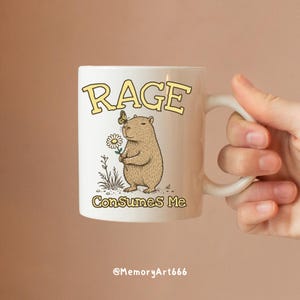Funny capybara meme PNG SVG design featuring a cute vintage-style capybara holding a daisy flower with a butterfly resting on its head and bold retro “RAGE Consumes Me” typography. Funny sarcastic animal graphic with whimsical hand-drawn line art, soft neutral tones, and trendy unhinged aesthetic. Perfect for funny t-shirts, hoodies, mugs, tote bags, stickers, sublimation projects, Cricut SVG cut files, retro boutique apparel, instant digital download, 300 DPI transparent background.