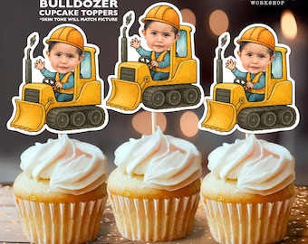 May include: Three cupcakes topped with white frosting, each adorned with a personalized bulldozer cupcake topper. The toppers feature a child's face in a yellow bulldozer. Text on the toppers reads "Personalized BULLDOZER CUPCAKE TOPPERS".