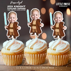 May include: Three cupcakes topped with white frosting, each adorned with a personalized Jedi Knight cupcake topper. The toppers feature a cartoon image of a child holding a blue lightsaber and wearing a brown robe. Text on the image reads "Personalized Jedi Knight Cupcake Toppers".