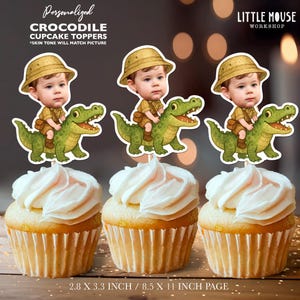 Op de afbeelding: Drie cupcakes met witte glazuur, elk versierd met een gepersonaliseerde krokodil cupcake topper. De toppers tonen een kind dat op een groene alligator rijdt. Tekst op de toppers luidt "CROCODILE CUPCAKE TOPPERS". De toppers zijn 7,1 x 8,4 cm groot.