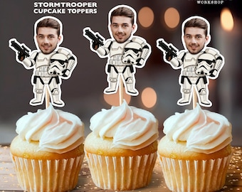 May include: Three cupcakes with white frosting, each topped with a personalized Stormtrooper cupcake topper. The toppers feature a person's face on a Stormtrooper figure holding a blaster and helmet. The toppers are 2.5 x 3.5 inches.