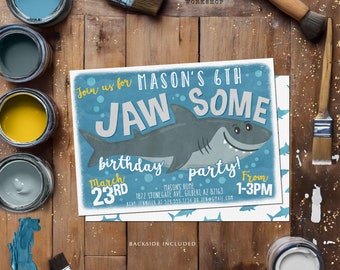 Puede incluir: Una invitación azul y blanca para una fiesta de cumpleaños con temática de tiburones. La invitación dice "¡Únete a la 6ª fiesta de cumpleaños JAW SOME de Mason!" con una ilustración de tiburón de dibujos animados. Botes de pintura y pinceles rodean la invitación.