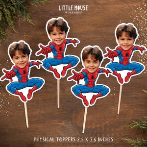 Puede incluir: Cuatro adornos para tartas con tem&aacute;tica de Spiderman con la cara de un ni&ntilde;o. Los adornos tienen forma de Spiderman, con trajes rojos y azules. Cada adorno mide 6,35 cm x 9,14 cm.