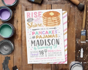 May include: A pink, blue, and yellow invitation for a pancake and pajamas party for a child turning five. The invitation features a stack of pancakes with butter and syrup, a bunny rabbit, and the text "Rise and Shine, Join us for Pancakes and Pajamas, Madison is turning 5!"