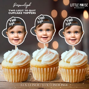 May include: Three cupcakes with white frosting, each topped with a personalized face cutout wearing a black baseball cap. The text on the cap reads "TWO Legit". The image also includes the text "Personalized TWO LEGIT TO QUIT CUPCAKE TOPPERS".