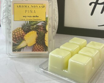 May include: Six yellow soy wax melts in a clear plastic container. The container has a label that says "Aroma Nova" and "Pina" with a pineapple graphic. The label also says "soy wax melts" and "1.26 oz | 6 count | Handmade".