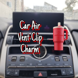 Può includere: Ciondolo per clip di ventilazione dell'aria per auto rosso con la scritta "Stanley" sul lato.