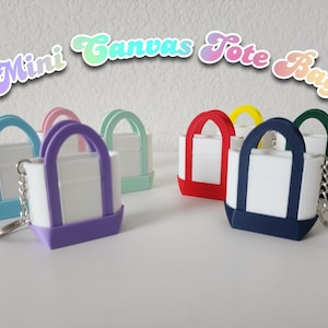 3D printed Trader Joe’s mini canvas tote bag keychain set in all 8 colors: red, blue, green, yellow, pastel pink, pastel purple, pastel green, pastel blue. Realistic miniature replica of the iconic Trader Joe’s shopping bag, perfect for keychains, backpacks, or as collectible bag charms. Handmade and eco-friendly, ideal gift for Trader Joe’s fans, foodies, or novelty accessory lovers. Great for collectors, stocking stuffers, or unique grocery-themed gifts.