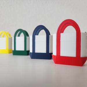3D printed Trader Joe’s mini canvas tote bag keychain set in all 8 colors: red, blue, green, yellow, pastel pink, pastel purple, pastel green, pastel blue. Realistic miniature replica of the iconic Trader Joe’s shopping bag, perfect for keychains, backpacks, or as collectible bag charms. Handmade and eco-friendly, ideal gift for Trader Joe’s fans, foodies, or novelty accessory lovers. Great for collectors, stocking stuffers, or unique grocery-themed gifts.