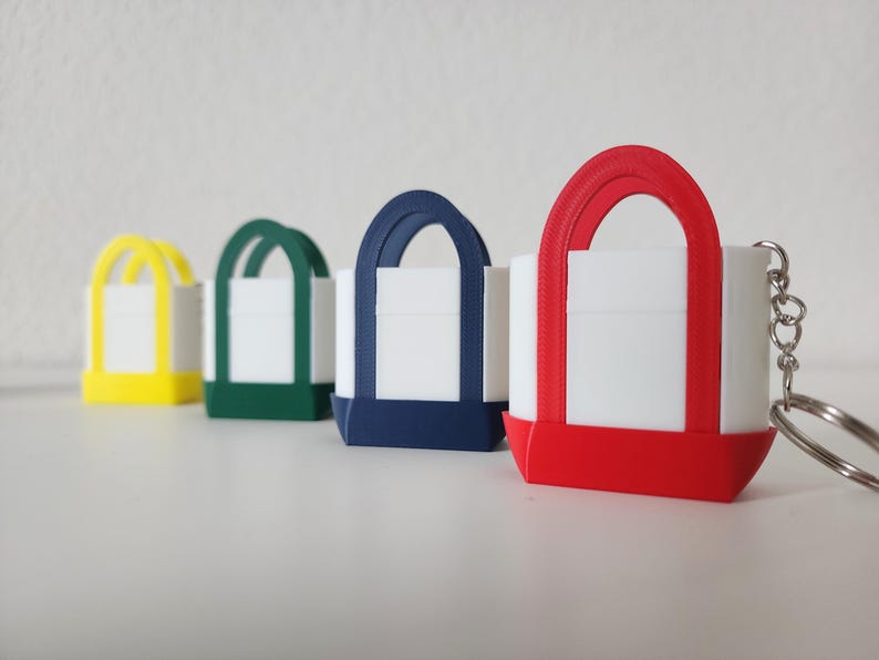 3D printed Trader Joe’s mini canvas tote bag keychain set in all 8 colors: red, blue, green, yellow, pastel pink, pastel purple, pastel green, pastel blue. Realistic miniature replica of the iconic Trader Joe’s shopping bag, perfect for keychains, backpacks, or as collectible bag charms. Handmade and eco-friendly, ideal gift for Trader Joe’s fans, foodies, or novelty accessory lovers. Great for collectors, stocking stuffers, or unique grocery-themed gifts.