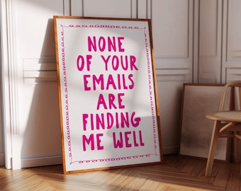 May include: A framed print with the text "NONE OF YOUR EMAILS ARE FINDING ME WELL" in bright pink. The print has a white background with a decorative pink border and a wooden frame. The print is leaning against a white wall.