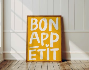 May include: A framed print with a yellow background and white text that says "BON APPETIT".