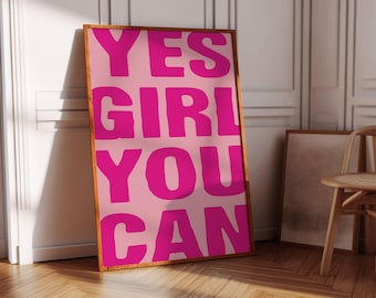 May include: A pink and magenta framed poster with the text "YES GIRL YOU CAN" in bold, magenta letters.