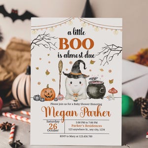 May include: Halloween-themed baby shower invitation with the text "a little BOO is almost due." The invitation features a cartoon ghost wearing a witch hat, a cauldron, and a pumpkin. The invitation is for Megan Parker.