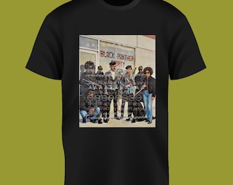 May include: Black t-shirt with a graphic print depicting a group of people and the text "BLACK PANTHER PARTY". The image shows a group of people standing in front of a building.