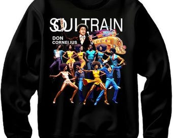 May include: Black sweatshirt with a white graphic of a group of people dancing and a train with the text "Soul Train Don Cornelius" on it.