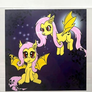 May include: A square art print featuring two yellow pony-like creatures with pink manes, bat-like wings, and red eyes. One creature is sitting while the other is flying against a dark purple background with a subtle black floral pattern and stars.