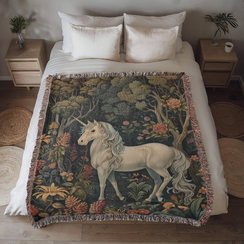 May include: A white unicorn with a long flowing mane and tail stands in a lush green forest with colorful flowers. The unicorn is depicted in a tapestry style with intricate details.