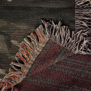 May include: Close-up of a woven tapestry with a colorful fringe. The tapestry is made of a variety of colors, including red, blue, green, and yellow. The fringe is made of a variety of colors, including black, white, and brown.