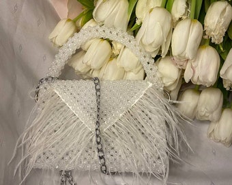 white beaded bag with feathers