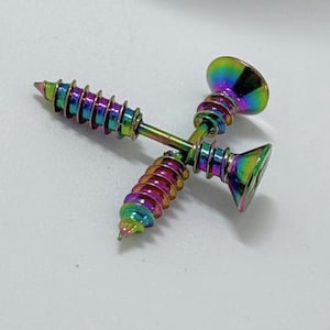 May include: Two iridescent screw-shaped earrings. The earrings have a rainbow finish, with colors shifting from green to purple. The screw heads are wide and flat, and the threads are clearly defined. The earrings are set against a white background.