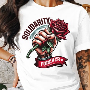 May include: White t-shirt with a graphic of a fist holding a red rose with the text "Solidarity Forever" and a small heart.