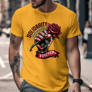 May include: Yellow t-shirt with a graphic of a hand holding a red rose with the text "Solidarity Forever".