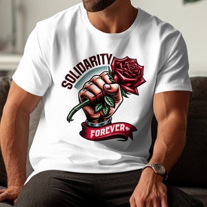 May include: White t-shirt with a graphic of a fist holding a red rose with green leaves. The text "SOLIDARITY FOREVER" is printed on the shirt.