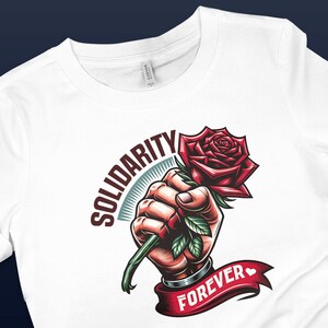 May include: White t-shirt with a graphic design of a fist holding a red rose with green leaves. The text "SOLIDARITY FOREVER" is written on a red ribbon.